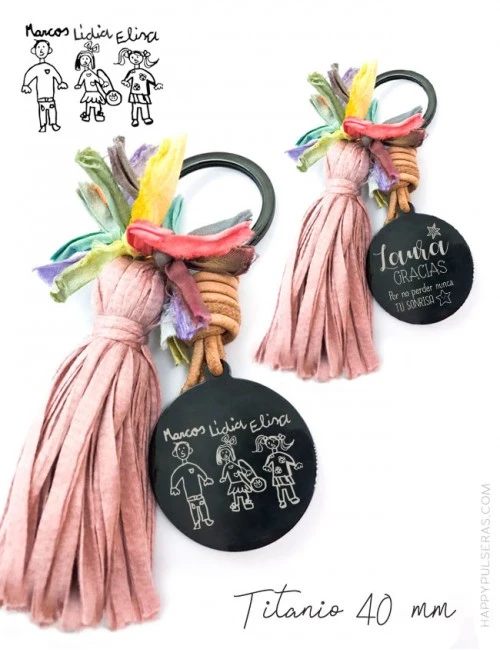 Llavero pompón grabado con un dibujo. Uno de los dibujos de tu hijo los grabamos sobre las medallas. Happpypulseras.