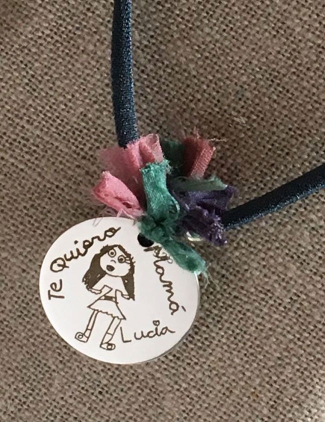 collar con elástico seda medalla 25 mm. grabada con dibujo de niño medalla con bolitas plata y pompón de seda de colores